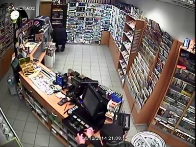 Záznam z bezpečnostní kamery, na kterém druhý z mužů bere peníze z pokladny.